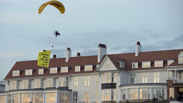 Un activista de Greenpeace con la pancarta 'Trump está muy por debajo de la media' pasa por el hotel en el que reside el presidente estadounidense en Escocia el 14 de julio - Sputnik Mundo