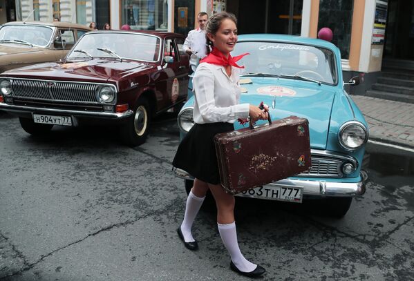Una chica se pasea antes de que empiece la carrera de autos retro Gorkyclassic en Moscú. - Sputnik Mundo