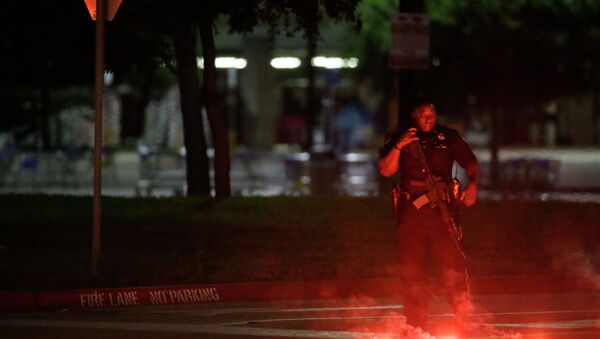 An armed police officer stands guard at a parking lot near the Curtis Culwell Center - Sputnik Mundo