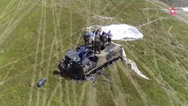 El aterrizaje en paracaídas más arriesgado: un vehículo blindado con su tripulación dentro (vídeo) - Sputnik Mundo