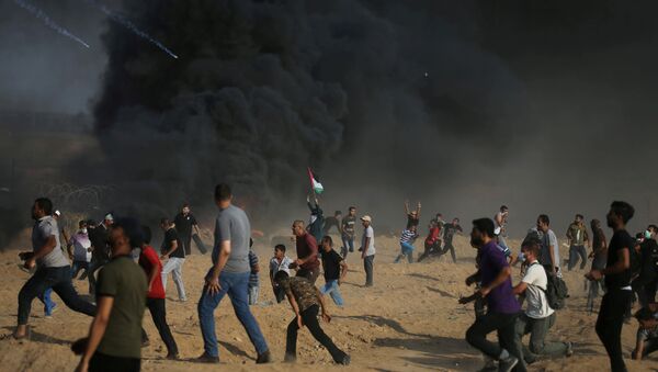Tear gas canisters are fired by Israeli troops towards Palestinian demonstrators as they run during a protest demanding the right to return to their homeland at the Israel-Gaza border, in the southern Gaza Strip - Sputnik Mundo