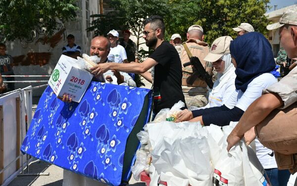 Aparte de comida, ropa, medicinas, mantas y colchones a los habitantes de Alepo también se les presta ayuda financiera - Sputnik Mundo