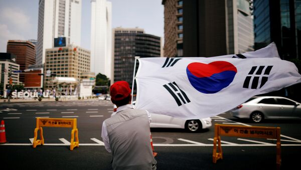Un miembro de un grupo cívico conservador agita la bandera nacional de Corea del Sur durante una protesta contra Corea del Norte - Sputnik Mundo
