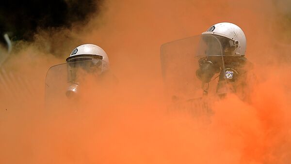 Policías antidisturbios en el humo durante los enfrentamientos con manifestantes frente al Parlamento griego el 29 de junio de 2011 en Atenas - Sputnik Mundo
