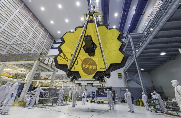 En esta foto los técnicos levantan el espejo del telescopio espacial James Webb utilizando una grúa en el Centro de Vuelo Espacial Goddard en Greenbelt, Maryland, en 2017. - Sputnik Mundo