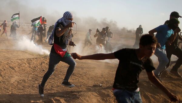 Palestinos huyen del gas lacrimógeno disparado por las tropas israelíes durante una protesta en la Franja de Gaza - Sputnik Mundo