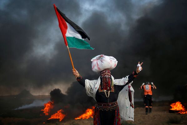 Una mujer con la bandera de Palestina, durante una manifestación al lado de la frontera con Israel. - Sputnik Mundo
