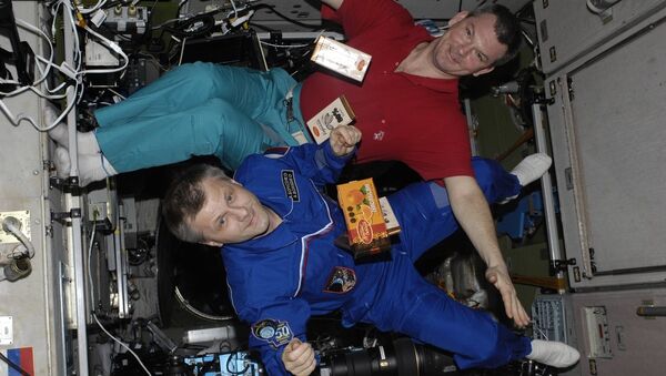 Los cosmonautas con barras de chocolate flotando en EEI (archivo) - Sputnik Mundo