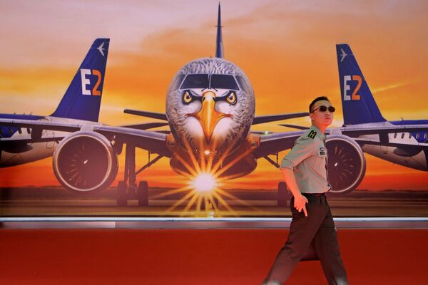 Una pancarta con el avión comercial de fabricación brasileña Embraer E190-E2 - Sputnik Mundo