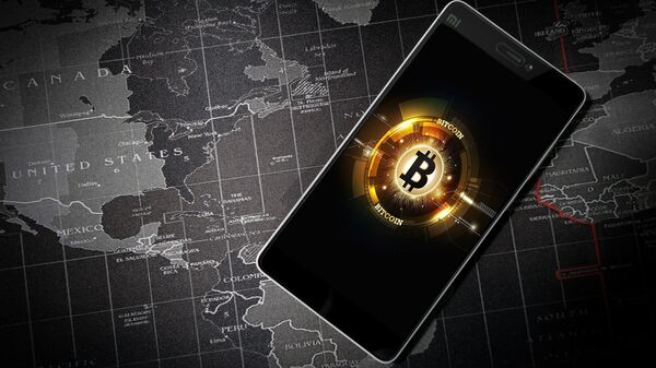 Un móvil con la imagen del logo de bitcoin   - Sputnik Mundo