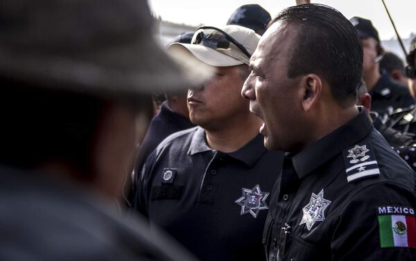 Un policía federal mexicano, Juan Carlos Morán, impide el paso de la manifestación centroamericana a la frontera con EEUU en el paso peatonal el Chaparral - Sputnik Mundo