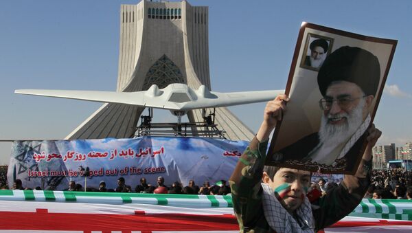 Un niño iraní sostiene el retrato del líder supremo de Irán ante la réplica del dron RQ-170 estadounidense capturado en 2012. - Sputnik Mundo