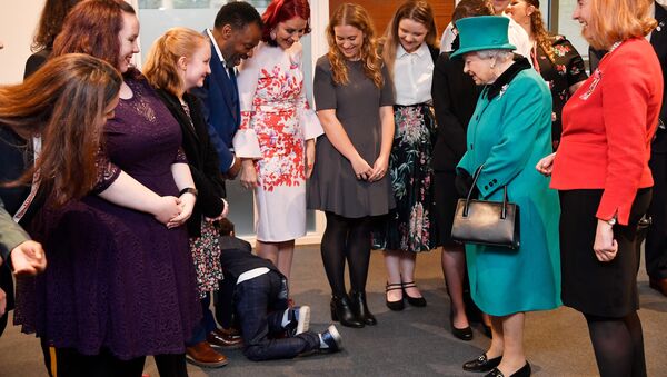 Un niño se arrastra mientras la reina británica Isabel visita la organización benéfica infantil Coram en Londres - Sputnik Mundo