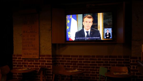 El presidente de Francia, Emmanuel Macron, en la pantalla de una tele - Sputnik Mundo