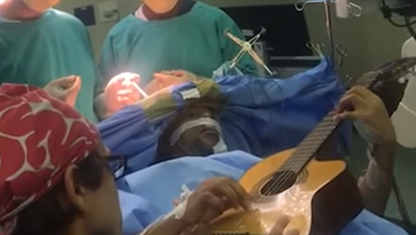 Un músico de Sudáfrica toca la guitarra durante una operación quirúrgica - Sputnik Mundo
