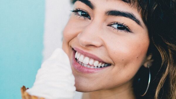 Una chica sonríe mientras come un helado - Sputnik Mundo