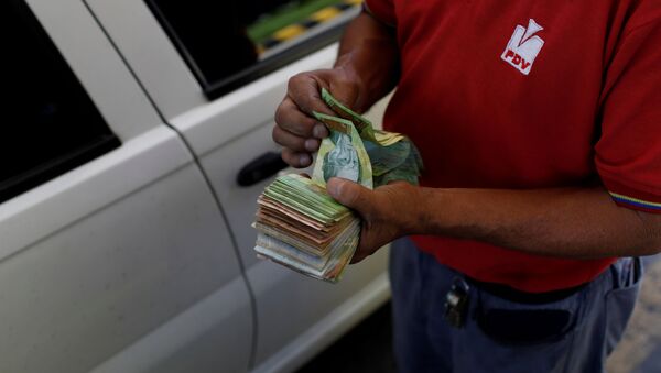 Bolivares venezolanos en las manos de una empleada de PDVSA - Sputnik Mundo