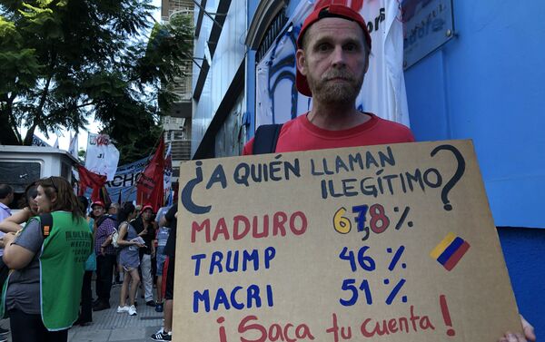 Una persona con una pancarta durante la vigilia antiimperialista frente a la Embajada venezolana en Buenos Aires - Sputnik Mundo