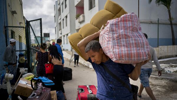 Un hombre carga sus pertenencias a un bus en La Habana después del tornado del 27 de enero - Sputnik Mundo