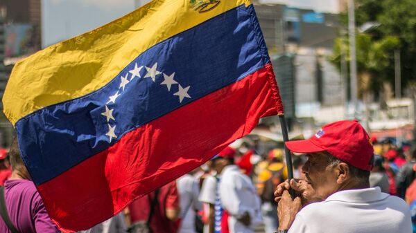 Un hombre con la bandera de Venezuela - Sputnik Mundo