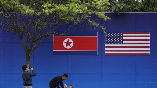Жители Ханоя позируют перед изображением северокорейского и американского флага в дни прохождения саммита КНДР-США в Ханое - Sputnik Mundo