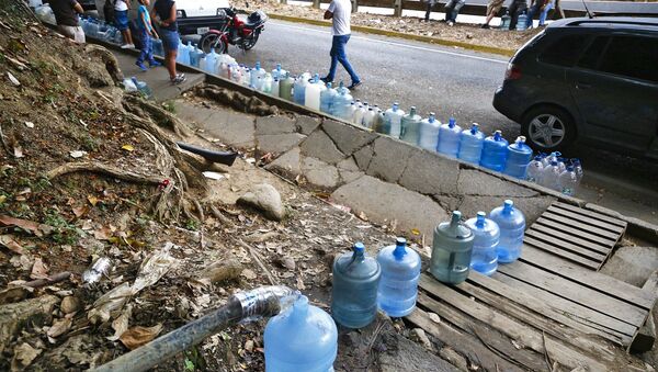 Venezolanos rellenan botellas de agua durante apagón en Caracas - Sputnik Mundo