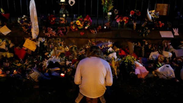 Un hombre reza cerca de la ofrenda floral a los víctimas del atentado en Christchurch, Nueva Zelanda - Sputnik Mundo