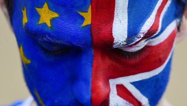 Un hombre con la cara pitada con las banderas de la UE y el Reino Unido - Sputnik Mundo