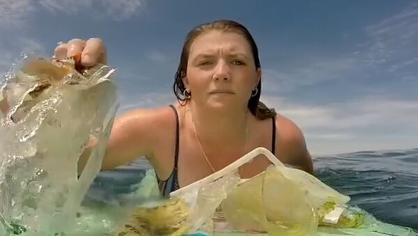 El triste vídeo de una surfista recogiendo basura del océano - Sputnik Mundo