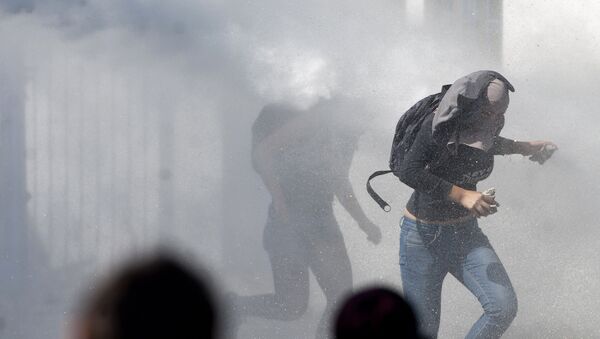 Manifestantes corriendo de la represión policial en el Día del Joven Combatiente de 2012 en Chile. - Sputnik Mundo