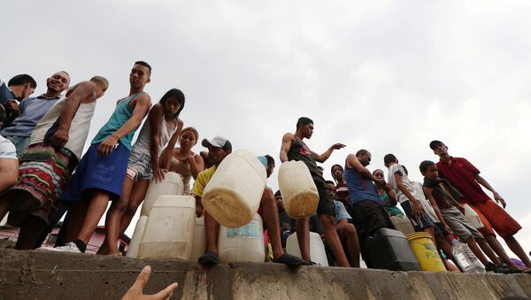 Venezolanos rellenan botellas de agua en Caracas - Sputnik Mundo