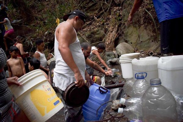 Los venezolanos reúnen agua de fuentes indicadas por las autoridades - Sputnik Mundo
