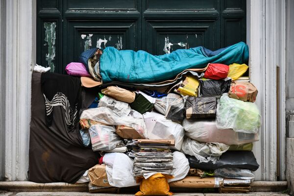 Un hombre sin hogar duerme en un montón de bolsas de plástico y periódicos en Roma, el 7 de abril de 2019 - Sputnik Mundo