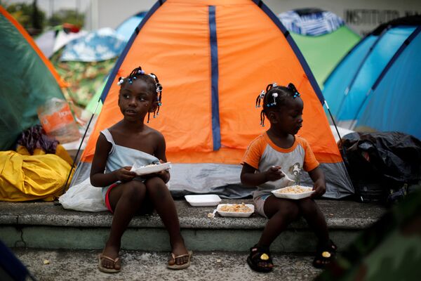 Niñas de África Ecuatorial comen fuera de su tienda en un campamento improvisado fuera de las instalaciones del Instituto Nacional de Migración (INM), en Tapachula (México), el 7 de abril de 2019 - Sputnik Mundo