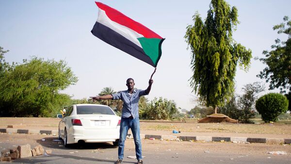 Un hombre con la bandera de Sudán - Sputnik Mundo