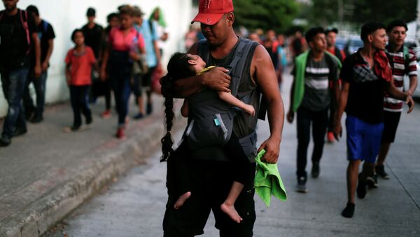 Hondureños que forman parte de una caravana de inmigrantes que se dirige a Estados Unidos caminan por Tapachula, México - Sputnik Mundo