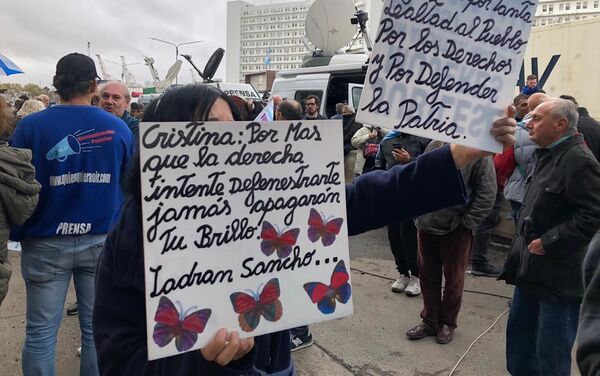 Mujer sostiene carteles en apoyo a Cristina Fernández fuera de tribunales - Sputnik Mundo