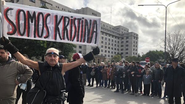 Un hombre sostiene una pancarta en apoyo a Cristina Fernández fuera de tribunales - Sputnik Mundo