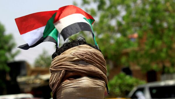 Un manifestantes con la bandera de Sudán (archivo) - Sputnik Mundo