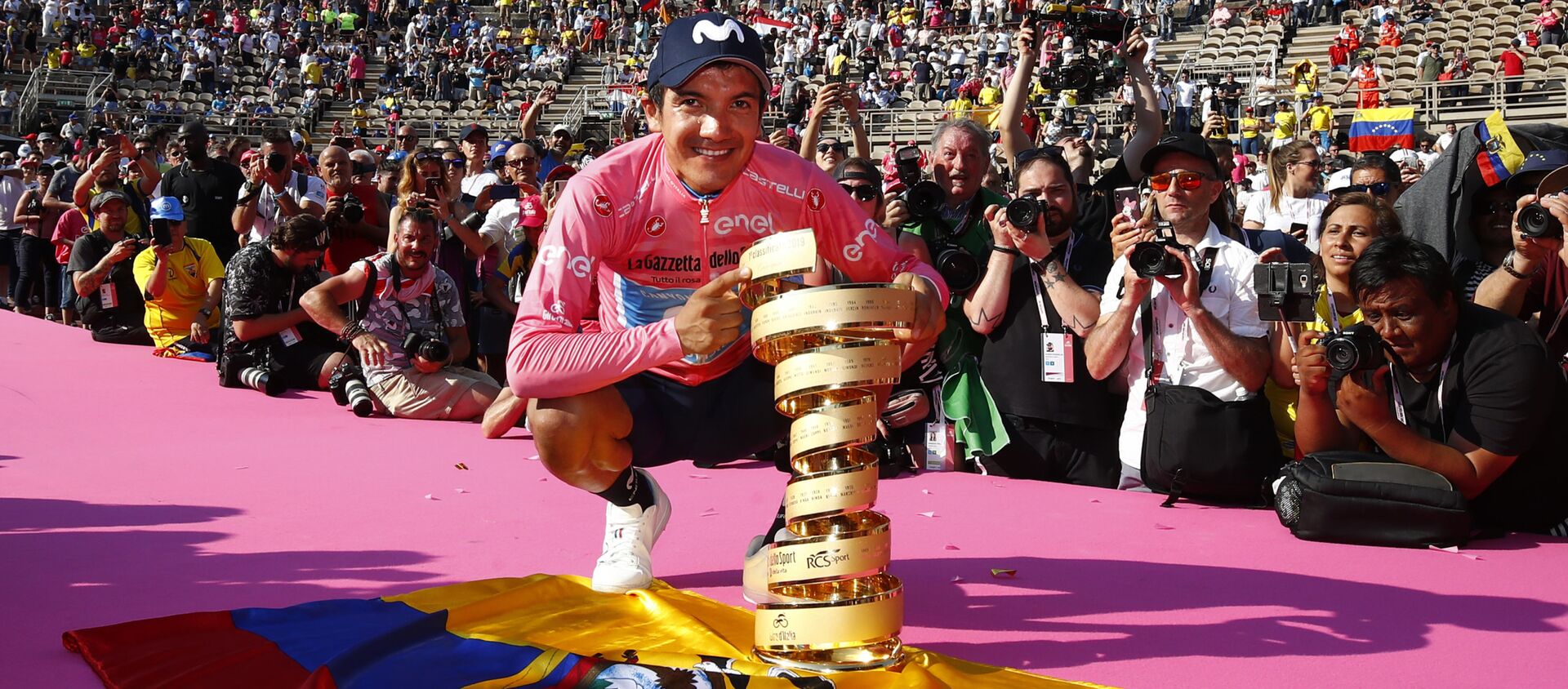 Richard Carapaz ostentando el primer premio del Giro de Italia 2019 sobre la bandera de Ecuador - Sputnik Mundo, 1920, 04.06.2019