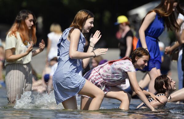 Unas chicas se refrescan en una fuente del Parque Gorki de Moscú durante el calor del mediodía. - Sputnik Mundo