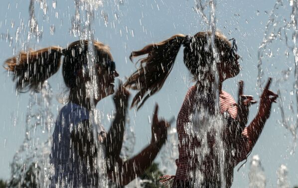 Unas mujeres se refrescan en una fuente en un caluroso día de verano en el centro de Moscú. - Sputnik Mundo