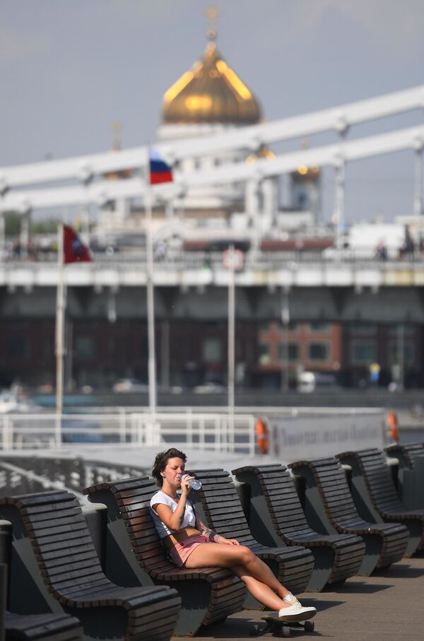 Una chica sentada en un banco en el Parque Gorki. - Sputnik Mundo