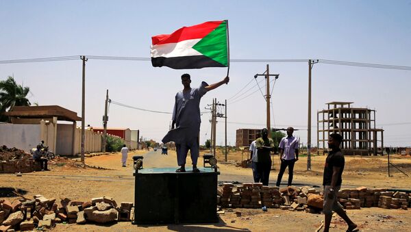 Un hombre con la bandera de Sudán - Sputnik Mundo