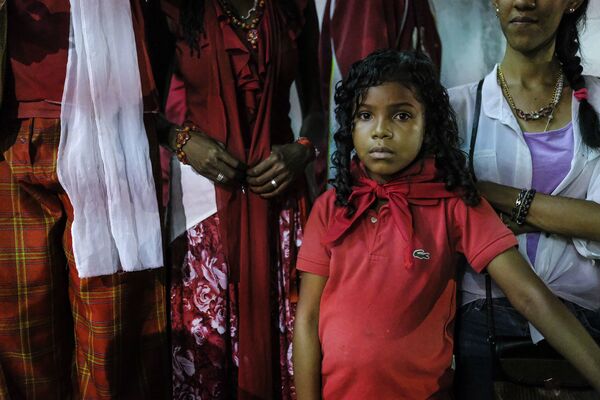 Una niña observa junto a sus familiares la celebración del Día de San Juan Bautista en Curiepe. - Sputnik Mundo