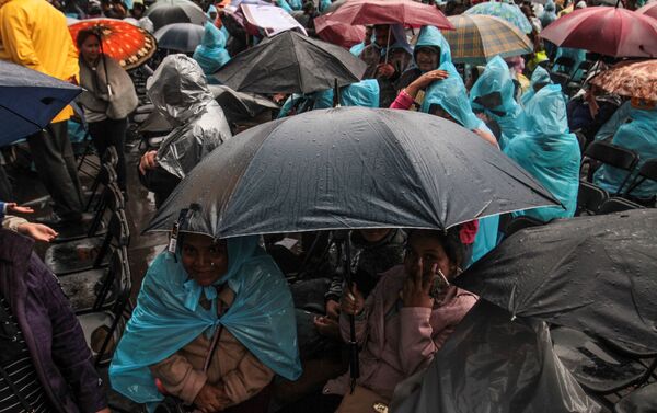 Asistentes se cubren de la lluvia durante el evento para la presentación del informe de actividades del presidente Andrés Manuel López Obrador en el Zócalo Capitalino - Sputnik Mundo