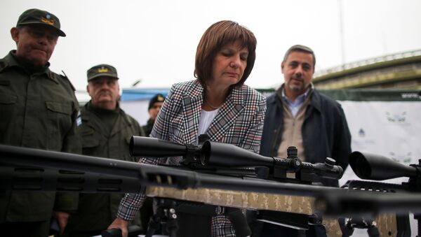 Ministra de Seguridad argentina Patricia Bullrich inspecciona un arma de fuego durante un acto - Sputnik Mundo