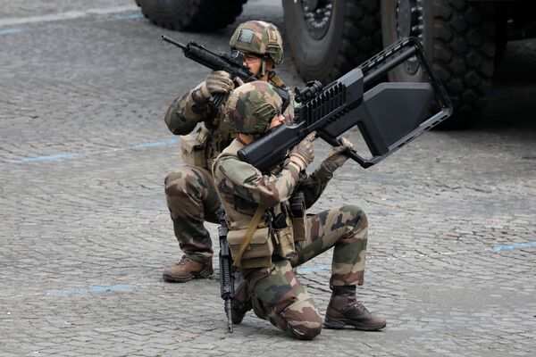 Soldados franceses realizan ejercicios durante el desfile militar con motivo del Día de la Bastilla en los Campos Elíseos de París. - Sputnik Mundo