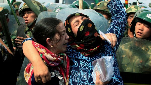 Dos mujeres uigures en frente de los policías chinos en la provincia de Sinkiang - Sputnik Mundo