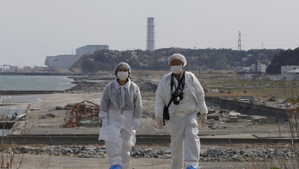 Personas en trajes de protección cerca de la planta nuclear Fukushima 2 - Sputnik Mundo